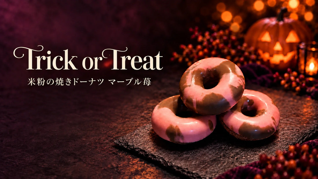 ハロウィンの灯りの中に並ぶマーブル苺の焼きドーナツ。Trick or Treatの文字入り